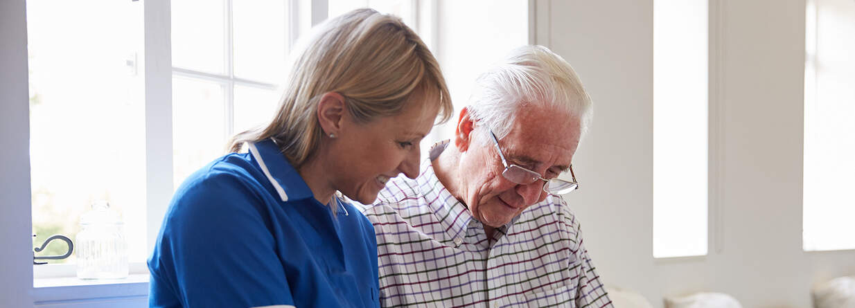 Clermont Park Senior Living Community in Denver, CO - senior man sitting looking at photo album